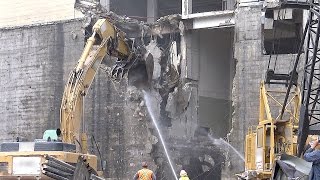 Demolition excavator demolishing part of a concrete and steel building [upl. by Markman]