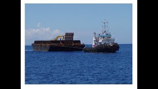 tugboats pull loading barge across the harborMost Powerful TugboatTugboat Pulling Videos [upl. by Ahsielat158]