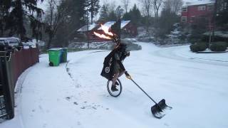 Unicycling while shoveling and playing a flaming bagpipe [upl. by Ewer]