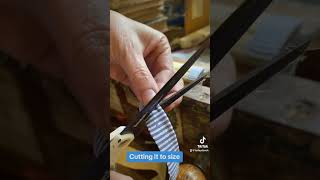 Bookbinder cuts and applies cloth headband to book bookbinding bookrepair bookbindery books [upl. by Ycniuqed]