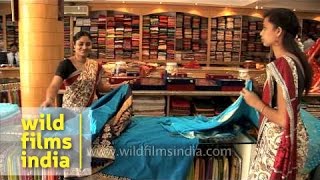 Sales woman displays a variety of sarees in India [upl. by Heady]