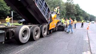 Dump truck feeding asphalt into the paver as the paver pushes the truck [upl. by Gottwald]