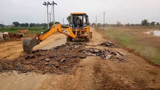 Backhoe loader Machine scarifying old bitumen surface of village road construction of pwd works [upl. by Iznyl]