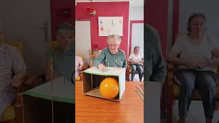 Players push long pins through a cardboard box attempting to pop the balloon [upl. by Eyatnod]