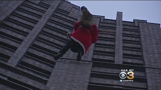 Santa Claus Rappels Down 24Story Building To Deliver Presents To Children [upl. by Angelia]