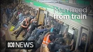 Faith in humanity restored as crowd lift train to save trapped man 2014  ABC News [upl. by Adleremse]