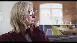 Thoughtful Senior Woman Sitting on Sofa Looking Away in Modern Living Room Video  WaveBreak Media [upl. by Anade]